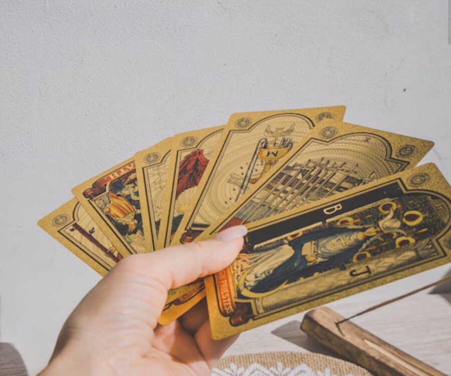 Gold tarot cards fanned in hand