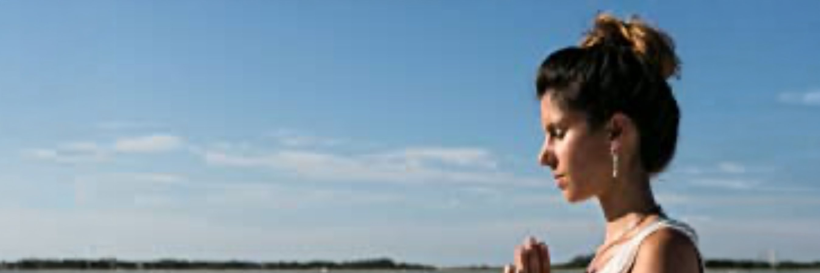 Woman meditating on the beach at peace